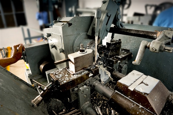 Metal lathe machine in operation with metal shavings, illustrating precision machining.